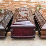 Wedding Turned War Zone—Who Pulled Trigger? Three wooden coffins arranged outdoors