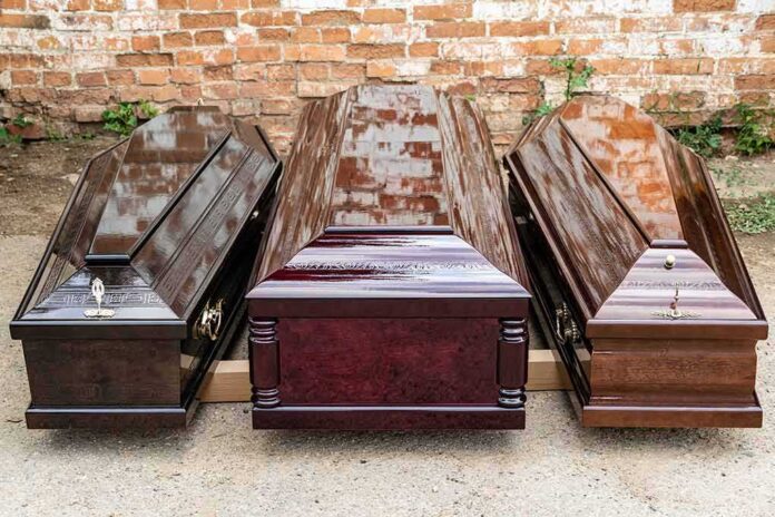 shutterstock_2201753131 Three wooden coffins arranged outdoors