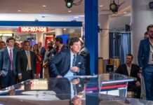 Pressure Mounts—Vance Refuses Tucker Denouncement News anchor at a studio desk with crowd and cameras in background