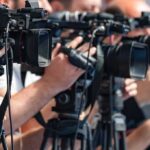 AI Athletes Dominate — What’s Beijing Building? television cameras on tripods at a media event