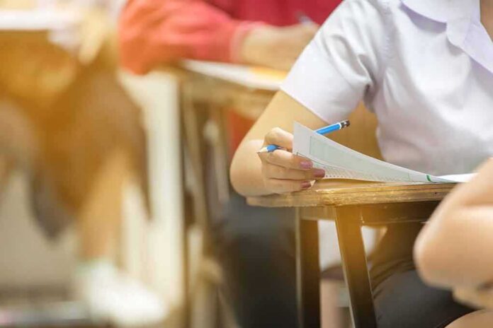 student filling out exam sheet at a desk