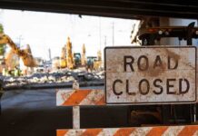 Historic Church Bulldozed – Sacred Ground Flipped For Fuel Road closed sign at construction site under overpass