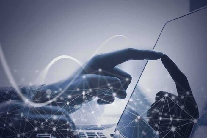 shutterstock_735977854 Hand touching a tablet screen with abstract network overlay