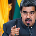 Nicolás Maduro speaking at a podium, pointing forward