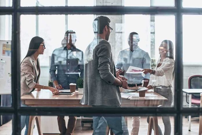 shutterstock_1059775265 Team meeting in a modern office behind glass windows