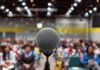 Microphone on stage facing a blurred audience