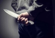 School Panic – Knife Plot Sparks Nationwide Sweeps person holding a large knife behind their back