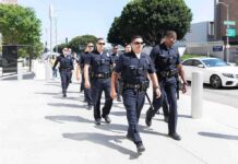 Police Ranks Shrink – Chaos Creeps In Police officers walking in formation on a city sidewalk