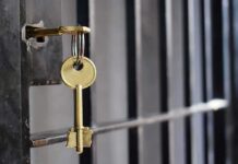 Cop Turned Welfare Check Into House Grab Golden key hanging from a lock on a metal jail cell door
