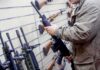 Teens Arm Cartels – High School Gun Pipeline Exposed Person examining a black rifle in a gun store