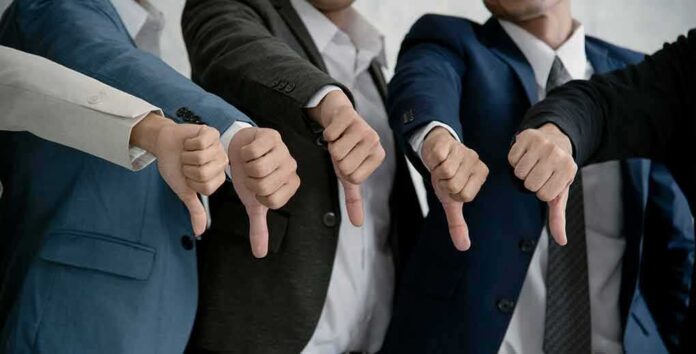 shutterstock_1182017491 Businesspeople giving thumbs down in a row