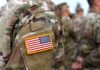 Night Curfew Slams U.S. Troops U.S. flag patch on a camouflage military uniform