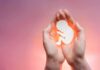 Twin Pregnancy Payout? Outrage Erupts Over $200K Abortion Deal hands cupping a fetal silhouette on pink background