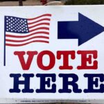 voting sign with arrow and American flag