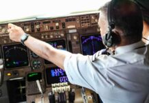 Cockpit Attack Twist: Iran Link Looming? Pilot adjusting controls in an airplane cockpit