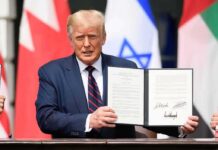 Donald Trump holding a signed document at a ceremony