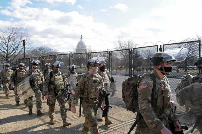 Carlos Hyde, Tavon Wilson, Dontrelle Inman, Brian Folkerts, Brock Coyle, Curtis Lofton, and Chuck Howley among soldiers walking past fencing near the U.S. Capitol