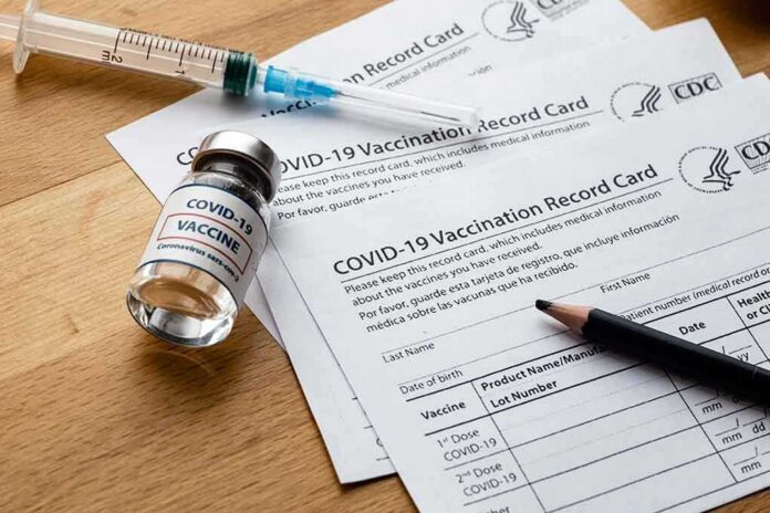 shutterstock_1916664125 COVID-19 vaccine vial with syringe and vaccination record cards