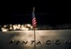Silent Bump: Troop Deaths Recounted Small American flag on a memorial with bokeh lights at night