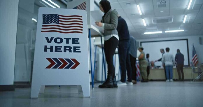 Vote here sign at a polling station with people in line