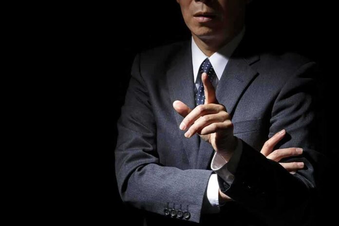 shutterstock_363484814 businessperson in suit gesturing with raised finger