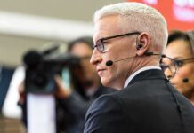 man in headset and glasses speaking into a microphone