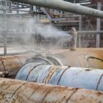 Industrial pipelines leaking steam in a processing plant