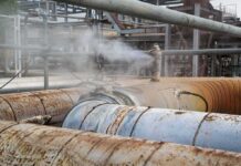 Industrial pipelines leaking steam in a processing plant
